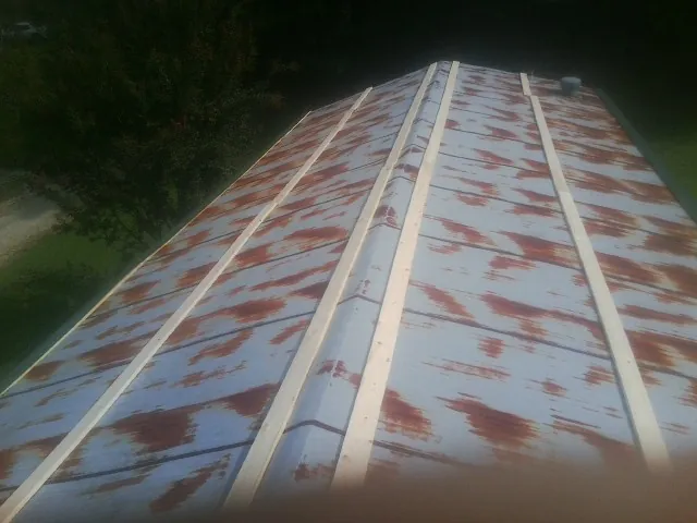 Rusted metal roof panels with new wood purlins before replacement — Storm Damage Roof Repair in Marble Rock by Roofing Brothers