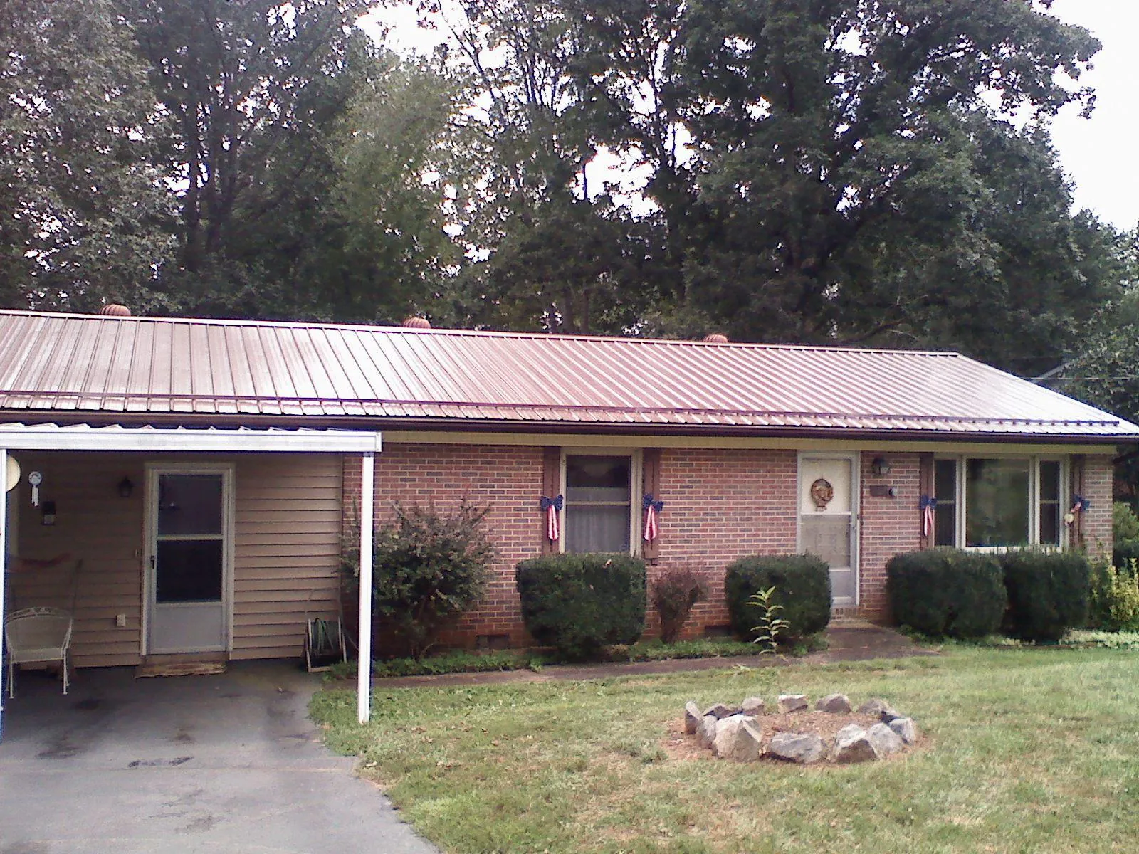 Bronze metal roof and carport on a brick ranch home — Roof Repair work by our crew in Marble Rock
